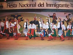 Personas vestidas con ropas típicas bailan una danza folclórica en la Fiesta Nacional del Inmigrante, en Oberá, Misiones