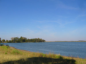 Orillas con pasto de la laguna La Arocena, en segundo plano la laguna
