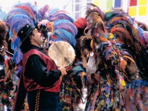 Con trajes típicos, descendientes de indígenas toman parte en una fiesta