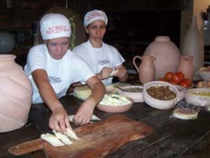 Mujeres con traje de cocineras preparan empandas